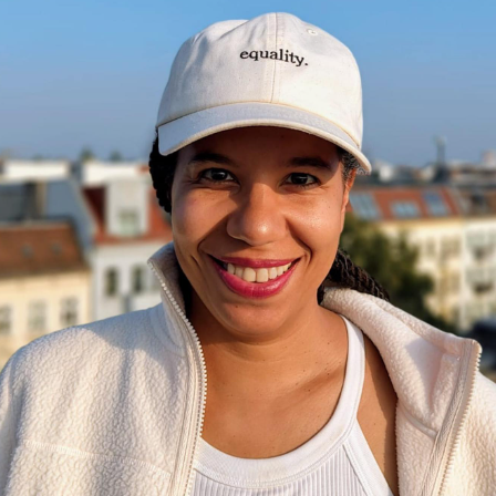 Frau lächelt und trägt Equality Cap von UN Women Deutschland | Credit: silberzahnstyle