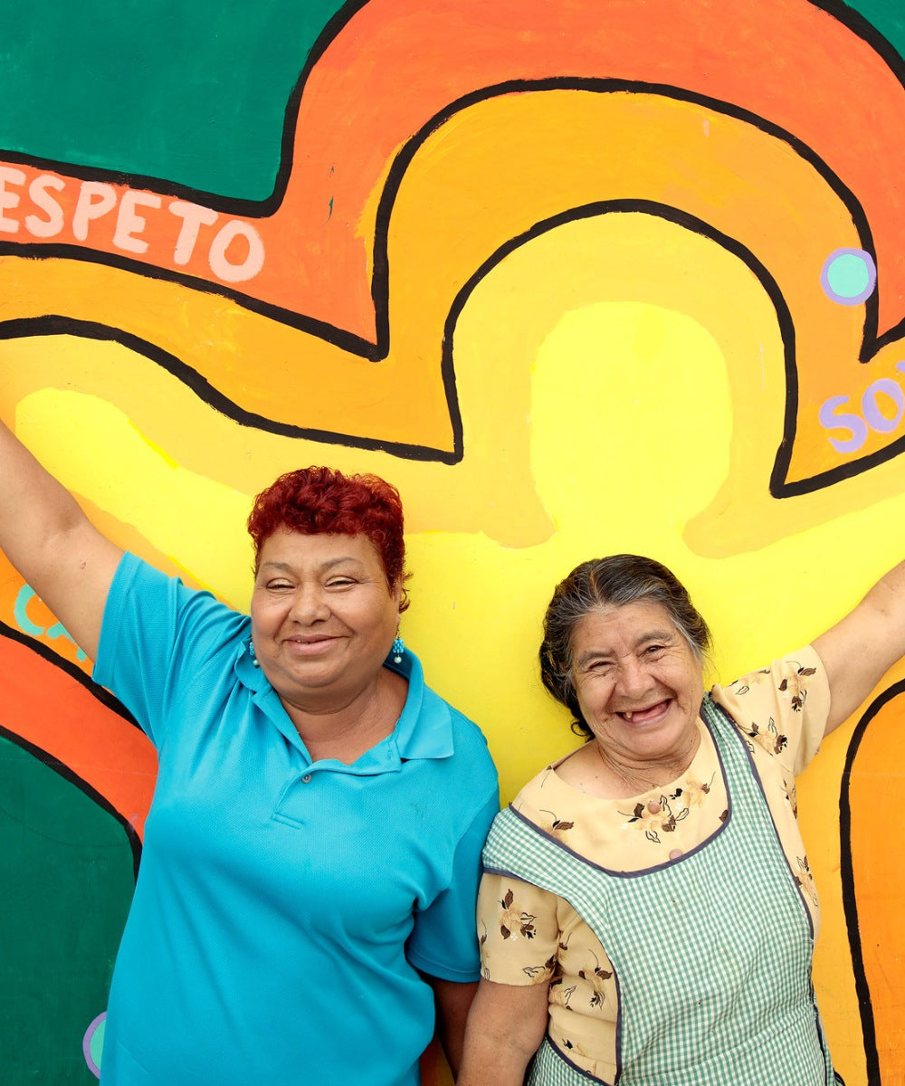 Zwei Frauen aus Guatemala stehen stolz vor einem bunten Wandgemälde | Credit: UN Women/ Ryan Brown