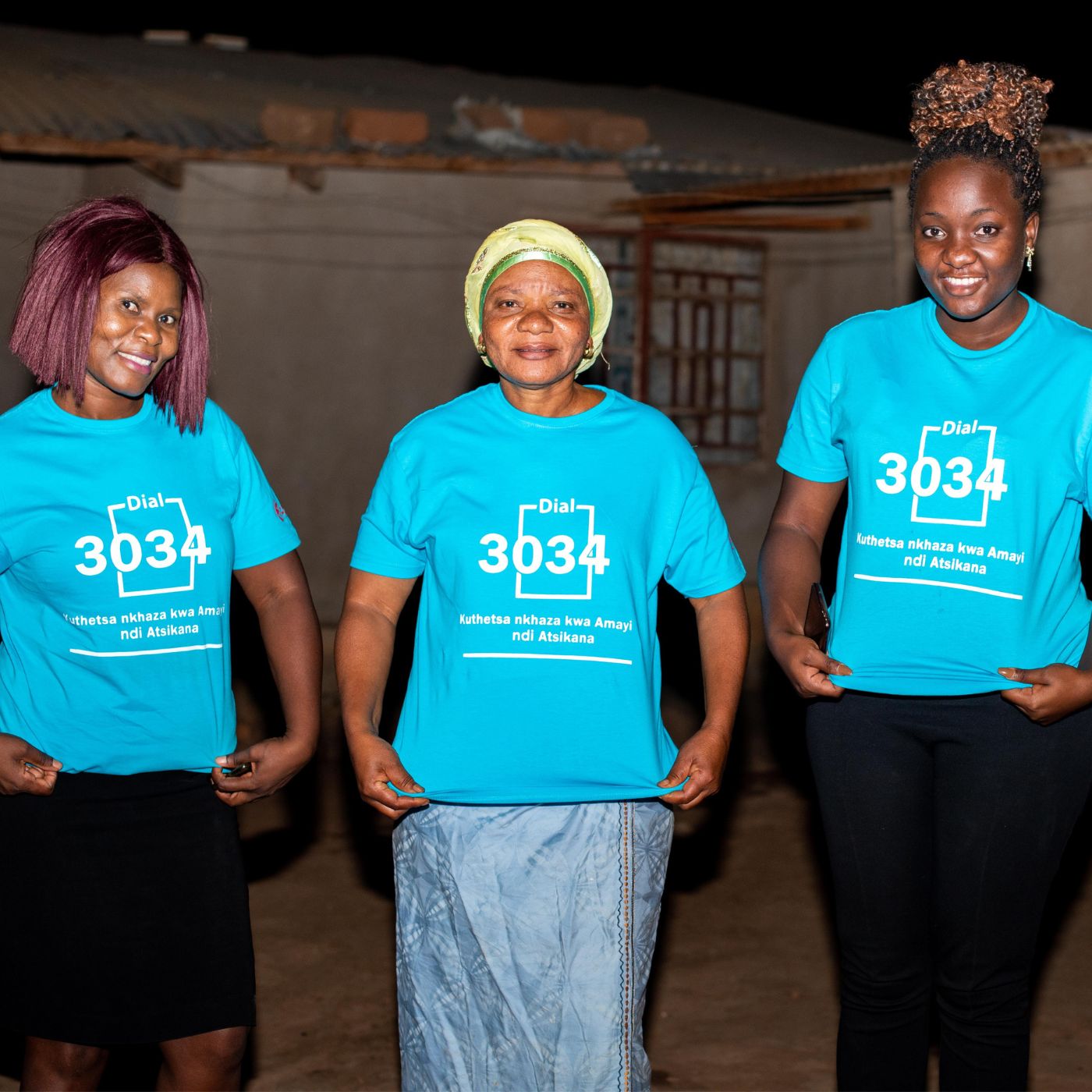 3 Frauen in blauem T-Shirt mit einer Notfall-Hotline für Frauen - Unterstützt vom UN Trust Fund zur Beendigung der Gewalt gegen Frauen und Mädchen | Credit: UN Women/ FACT Malawi
